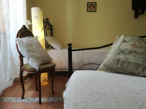 una camera con letto e sedia con cuscino di Villino Tokupellon Apartments a Cupello