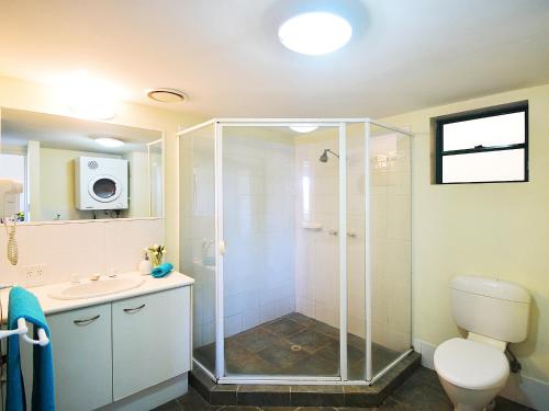 a bathroom with a shower and a toilet and a sink at Noosa River Sandy Shores in Noosaville