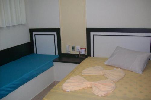 ein Schlafzimmer mit einem Bett mit zwei Handtüchern darauf in der Unterkunft Hotel Pousada Village in Sorocaba