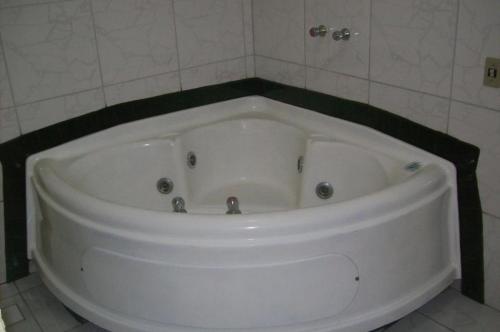 un bagno con grande vasca bianca di Hotel Pousada Village a Sorocaba