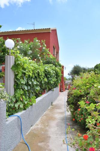 a garden with a blue hose attached to a wall at Appartements Luccisano in Borgo