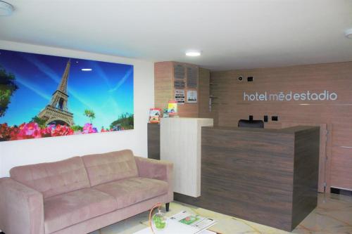 sala de estar con sofá y póster de la torre Eiffel en Hotel Med Estadio, en Medellín