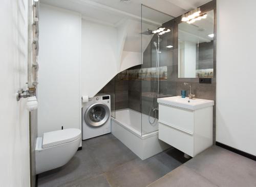 ein Badezimmer mit einer Waschmaschine, einer Waschmaschine und einem Trockner in der Unterkunft Vecbulduri Apartment Jurmala in Jūrmala