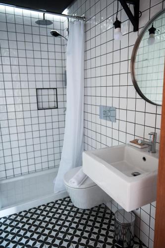 a white bathroom with a sink and a toilet at Lemon Tree Stay in Faro