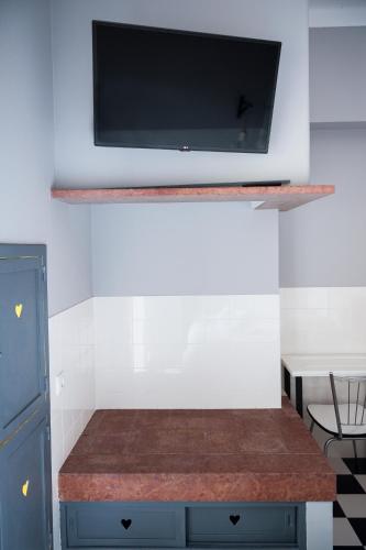 a flat screen tv on a wall above a counter at Lemon Tree Stay in Faro