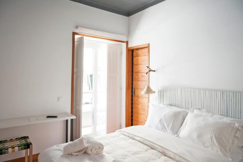 a bedroom with a white bed and a window at Lemon Tree Stay in Faro