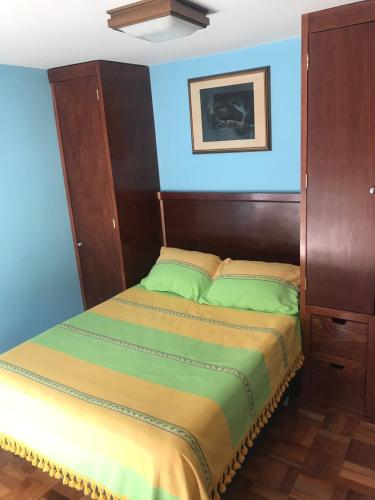 a bedroom with a bed with a blue wall at Monoambientes Cuauhtemoc in Mexico City