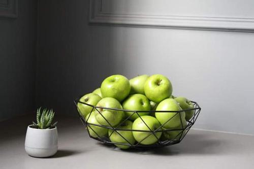 a bowl of green apples sitting next to a cactus at Mrs Banks Hotel in Sydney