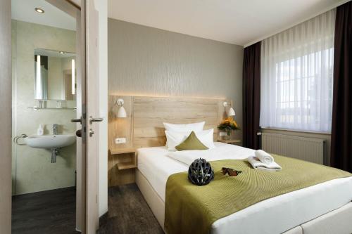 um quarto de hotel com uma cama com um lavatório e um lavatório em Am Schloßbrunnen Bad Muskau em Bad Muskau