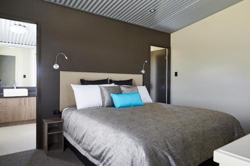 a bedroom with a large bed with a blue pillow at Ridgemill Estate in Stanthorpe