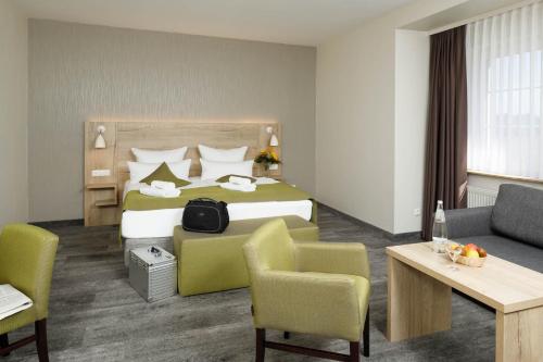 a hotel room with a large bed and a couch at Am Schloßbrunnen Bad Muskau in Bad Muskau