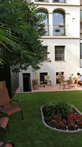 a building with a yard with chairs and a fire place at El Jardinet de Sant Esteve in Olot