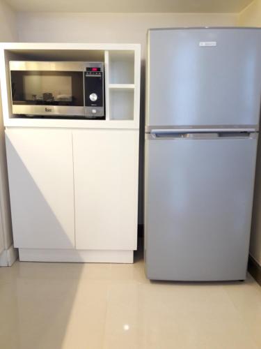 a kitchen with a microwave and a refrigerator at Bluesky Serviced Apartment Airport Plaza in Ho Chi Minh City