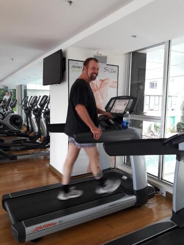 a man walking on a treadmill in a gym at Bluesky Serviced Apartment Airport Plaza in Ho Chi Minh City