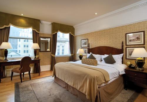 a hotel room with a large bed and a desk and a desk at Quebecs in Leeds