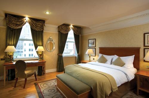 a bedroom with a large bed and a desk and a bed sidx sidx sidx sidx at Quebecs in Leeds