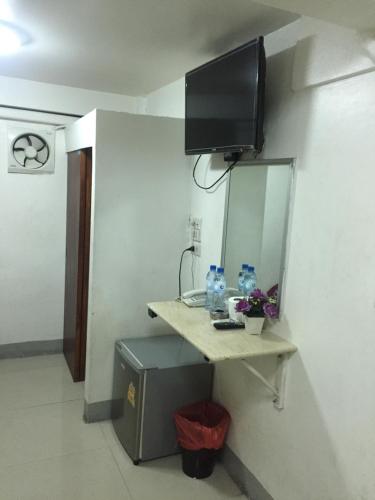 فندق Alsana في بانكوك: غرفة مع طاولة وتلفزيون على جدار