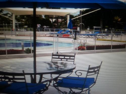 a table with two chairs and a swimming pool at HERMOSA CASAQUINTA FAMILIAR CONDOMINIO CAMPESTRE EL PEÑON Piscina Privada Campo de Golf in Girardot