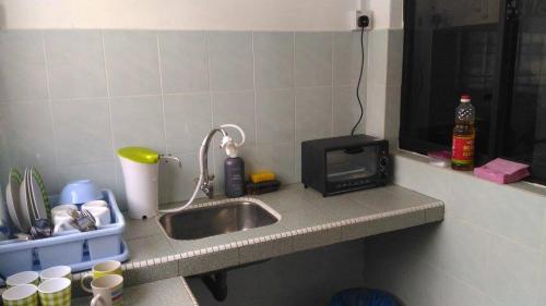 a kitchen counter with a sink and a microwave at J&P Homestays House 1 in Kampar