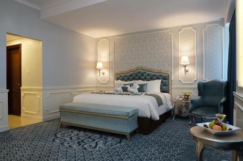 a bedroom with a bed and a chair and a table at Grand Keisha Yogyakarta in Yogyakarta