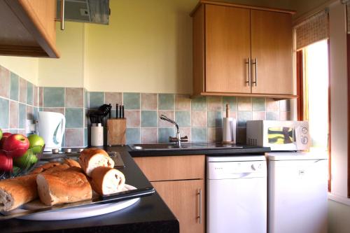 a kitchen with a tray of bread on a counter at Logierait Pine Lodges in Pitlochry