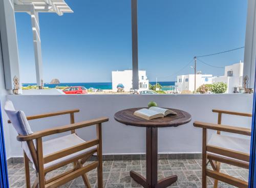 einen Tisch und Stühle auf einem Balkon mit Meerblick in der Unterkunft Villa Sosanna in Pollonia