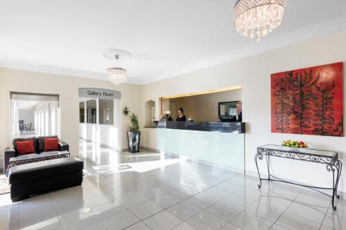 a living room with a couch and a table at Mercure Wagga Wagga in Wagga Wagga