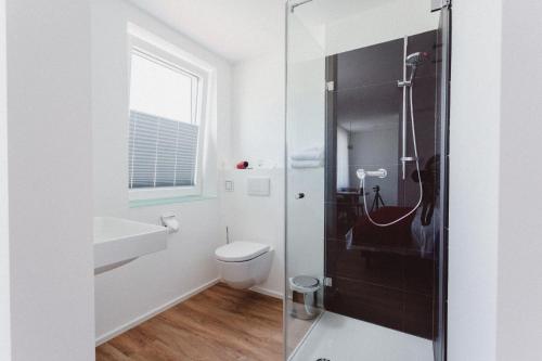 y baño con ducha, aseo y lavamanos. en HEIMAT | Hotel & Boarding House, en Mainburg