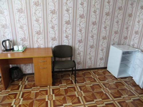 a desk and a chair in a room with a desk and a computer at Vershnyk in Cherkasy