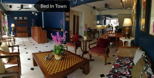 a living room with chairs and a table with flowers on it at Bed in Town in Chiang Mai