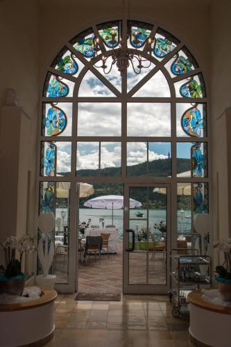 a large window in a building with a view of the water at Villa Christina in Pörtschach am Wörthersee