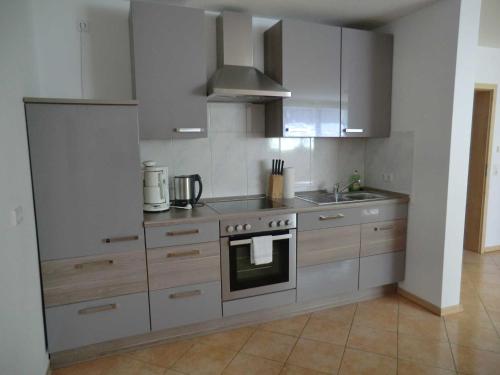 a kitchen with white cabinets and a stove top oven at Ferienwohnung Koch in Rust