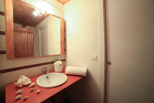 a bathroom with a sink and a mirror at Bosa Exclusive Apartments "Bosa Apartments" in Bosa