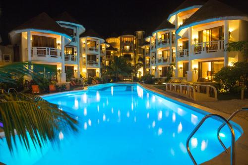 a swimming pool in front of some buildings at night at Ambassador In Paradise in Boracay