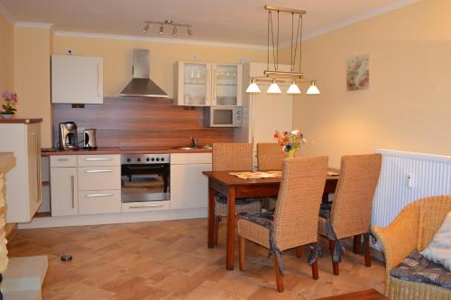 a kitchen with a wooden table and a dining room at Haus Bucheneck in Graal-Müritz