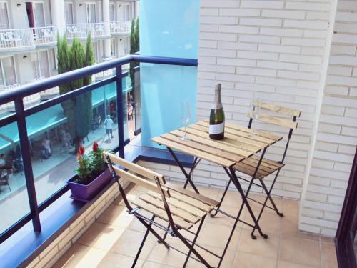 a table and chairs on a balcony with a bottle of wine at Apartamento Victor in Tossa de Mar