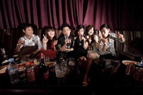a group of people sitting on a table with their hands up at NagaWorld Hotel & Entertainment Complex in Phnom Penh