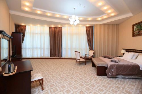 a large hotel room with a bed and a television at Spring Hotel in Novxanı