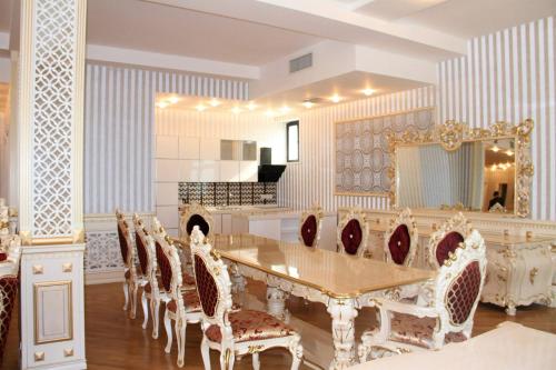 a dining room with a table and chairs and a mirror at Spring Hotel in Novxanı