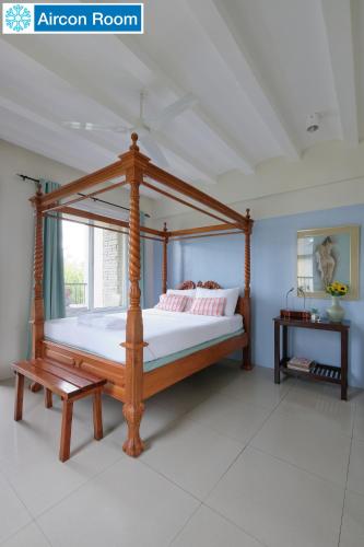a bedroom with a wooden canopy bed in a room at The Duyan House at Sinagtala Resort in Orani