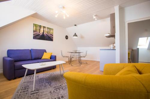 a living room with a blue couch and a table at Haapsalu Old Town Apartments in Haapsalu