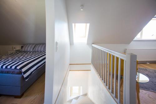 a white room with a bed and a staircase at Haapsalu Old Town Apartments in Haapsalu