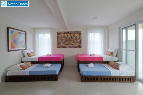 three beds sitting in a room with a window at The Duyan House at Sinagtala Resort in Orani
