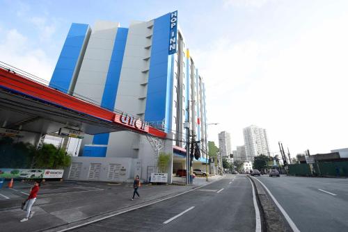 a building on a street with people walking on the street at Hop Inn Hotel Makati Avenue Manila in Manila