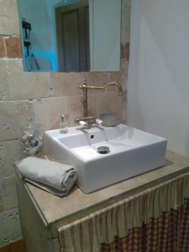 - un lavabo blanc avec un miroir au-dessus d'un comptoir dans l'établissement Maison de Campagne, à Sarragia