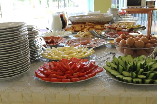 a buffet with plates and bowls of food on a table at Семеен Хотел Идън in Sveti Vlas