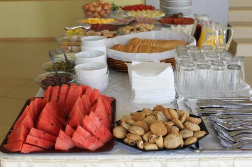 un buffet de alimentos con sandía y otros alimentos en una mesa en Семеен Хотел Идън en Sveti Vlas