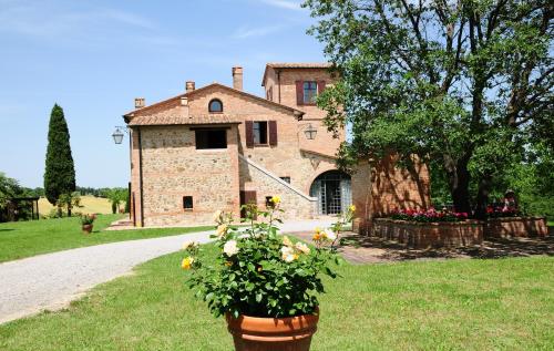a stone house with flowers in front of it at Agriturismo Chieteno con piscina e AC- Cetona in Cetona
