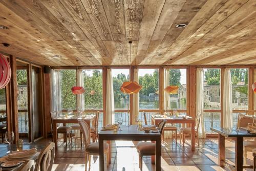 a restaurant with wooden ceilings and tables and chairs at Hacienda Zorita Wine Hotel & Spa in Valverdón
