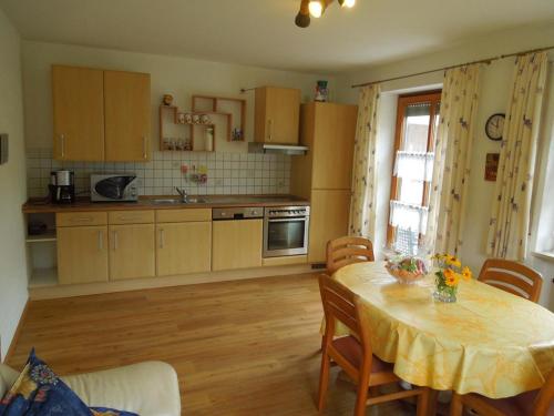 a kitchen with a table with chairs and a dining room at Ferienwohnung Scherr in Neunburg vorm Wald